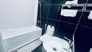 A modern bathroom with a bathtub, toilet, and sink.