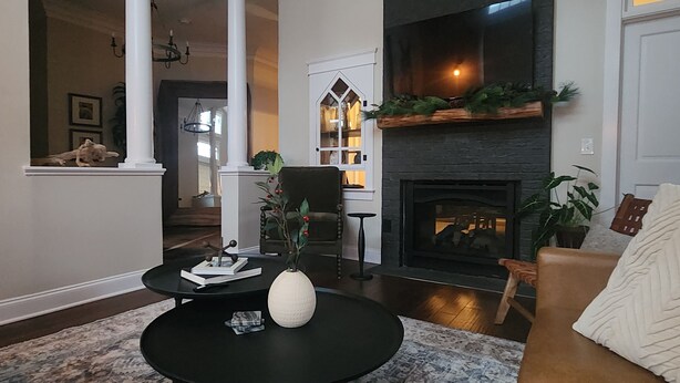 Un salon avec une cheminée, une table basse ronde et un canapé.