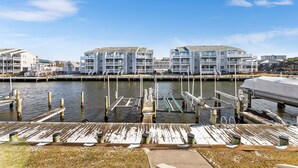 A waterfront property with multiple buildings, docked boats, and a wooden dock. - 2 BEDROOM 2 BATH AT ISLAND AT HIDDEN HARBOUR (Ocean City)