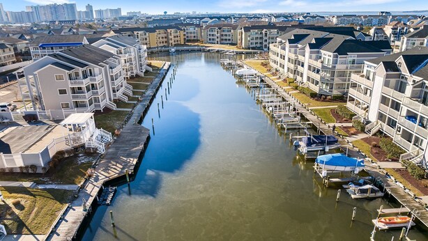 A marina with docked boats, connected to multi-story residential buildings with balconies. - 2 BEDROOM 2 BATH AT ISLAND AT HIDDEN HARBOUR (Ocean City)