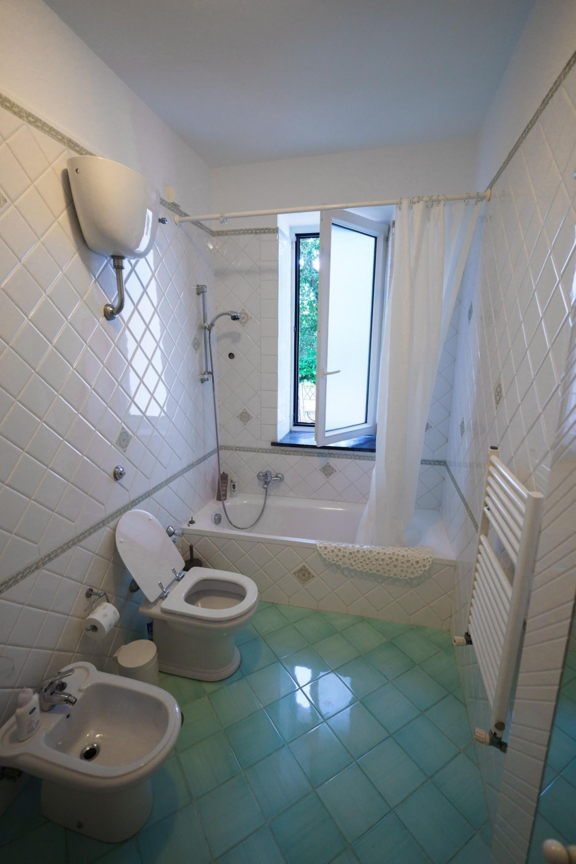 A bathroom with a toilet, bidet, and bathtub.