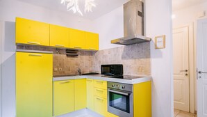 A kitchen with yellow cabinets, a stainless steel oven, and a microwave. - Illyria Old Town Apartment by DuHomes (Dubrovnik)