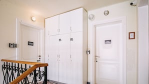 A hallway with a checkered floor, white doors, and a large white wardrobe with a sign indicating it is the Panorama Apartment. - Illyria Old Town Apartment by DuHomes (Dubrovnik)