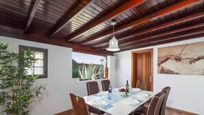 A dining area with a wooden ceiling, a table set for four, and a potted plant. - Villa Argentina - Three Bedroom Villa, Sleeps 6 (Montaña Roja)