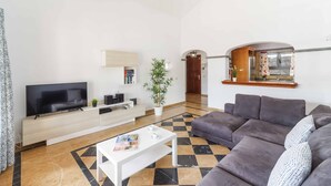 A modern living room with a flat-screen TV, a sofa, a coffee table, and a potted plant. - Villa Argentina - Three Bedroom Villa, Sleeps 6 (Montaña Roja)