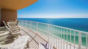 A balcony with lounge chairs and a view of the ocean. - Gorgeous Beach Retreat at Phoenix Gulf Towers (Orange Beach)
