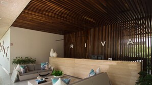 Un espace d’accueil moderne doté d’un plafond à lambris en bois, d’un comptoir de réception et d’un coin salon avec des canapés et une table basse.