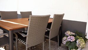 A dining area with a wooden table and wicker chairs. - Kuzey Apartments (Kappel-Grafenhausen)