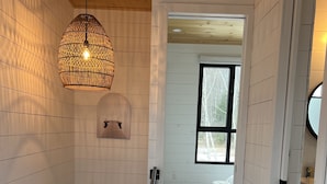 A wooden interior with a staircase, a hanging light fixture, and a window with a view of trees. - New construction, This Chalet is ready to enjoy all seasons ! (Saint-Michel-Des-Saints)