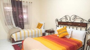 A bedroom with two beds, a window with curtains, and a nightstand. - Aigle Appart Hôtel  (Ouarzazate)