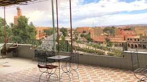 A balcony with a tiled floor, metal chairs, and a table. - Aigle Appart Hôtel  (Ouarzazate)