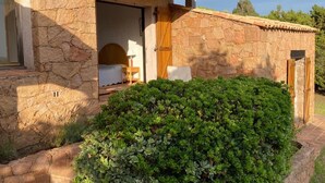 Un bâtiment en pierre avec une porte en bois et une fenêtre.