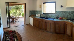Une cuisine avec un plan de travail en bois, un évier, une cuisinière et une fenêtre.