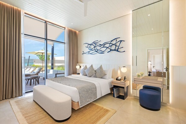 Una habitación de hotel moderna con una cama grande, un escritorio, una silla y vistas al exterior.