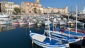 A marina with various boats docked, a historic building with a tower, and a clear blue sky. - Appartement à LA Ciotat Avec Grande Terrasse de 50m² à Deux pas du Vieux Port (LA CIOTAT)