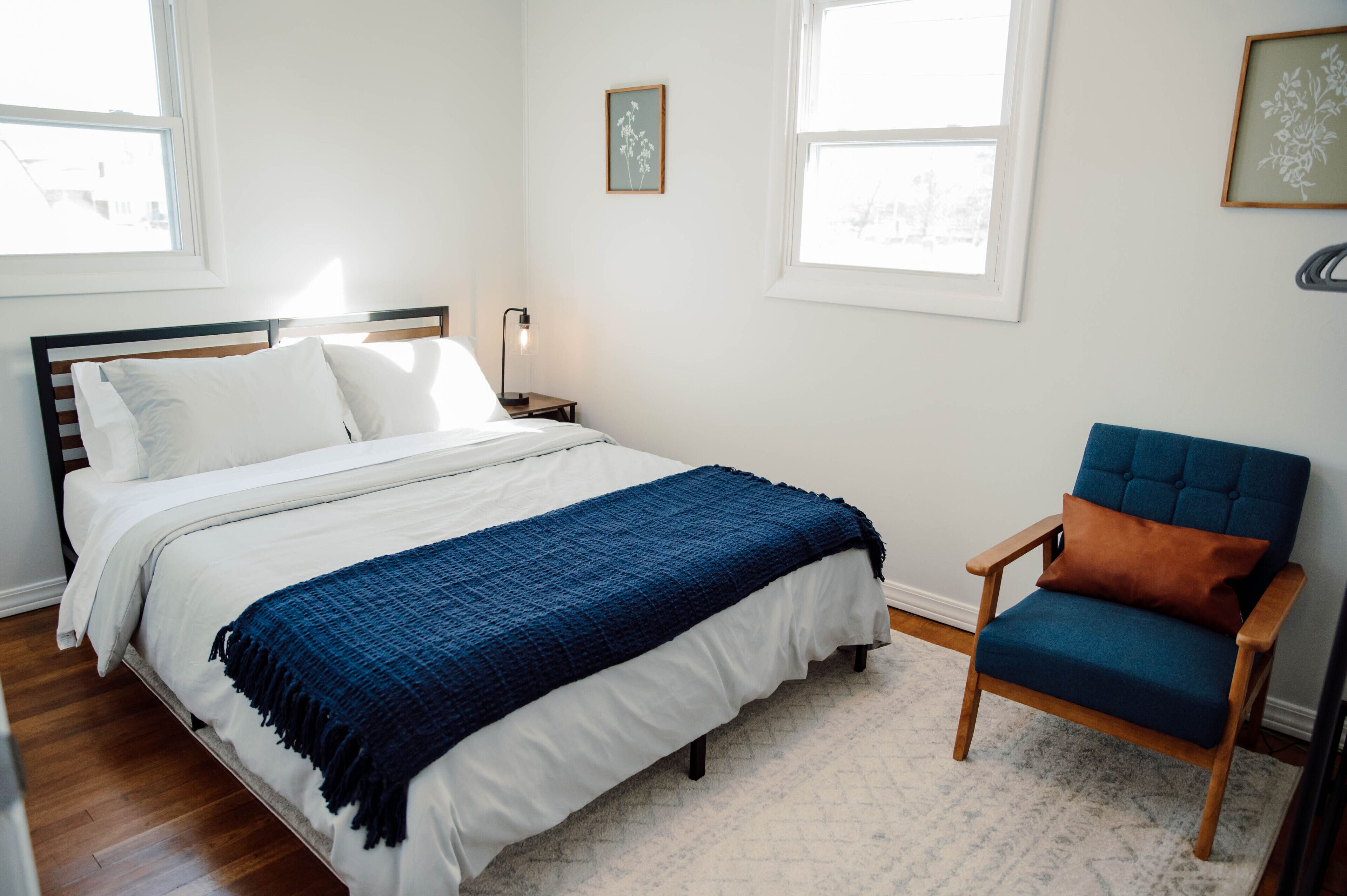 Un dormitorio con una cama, una silla y una mesita de noche.