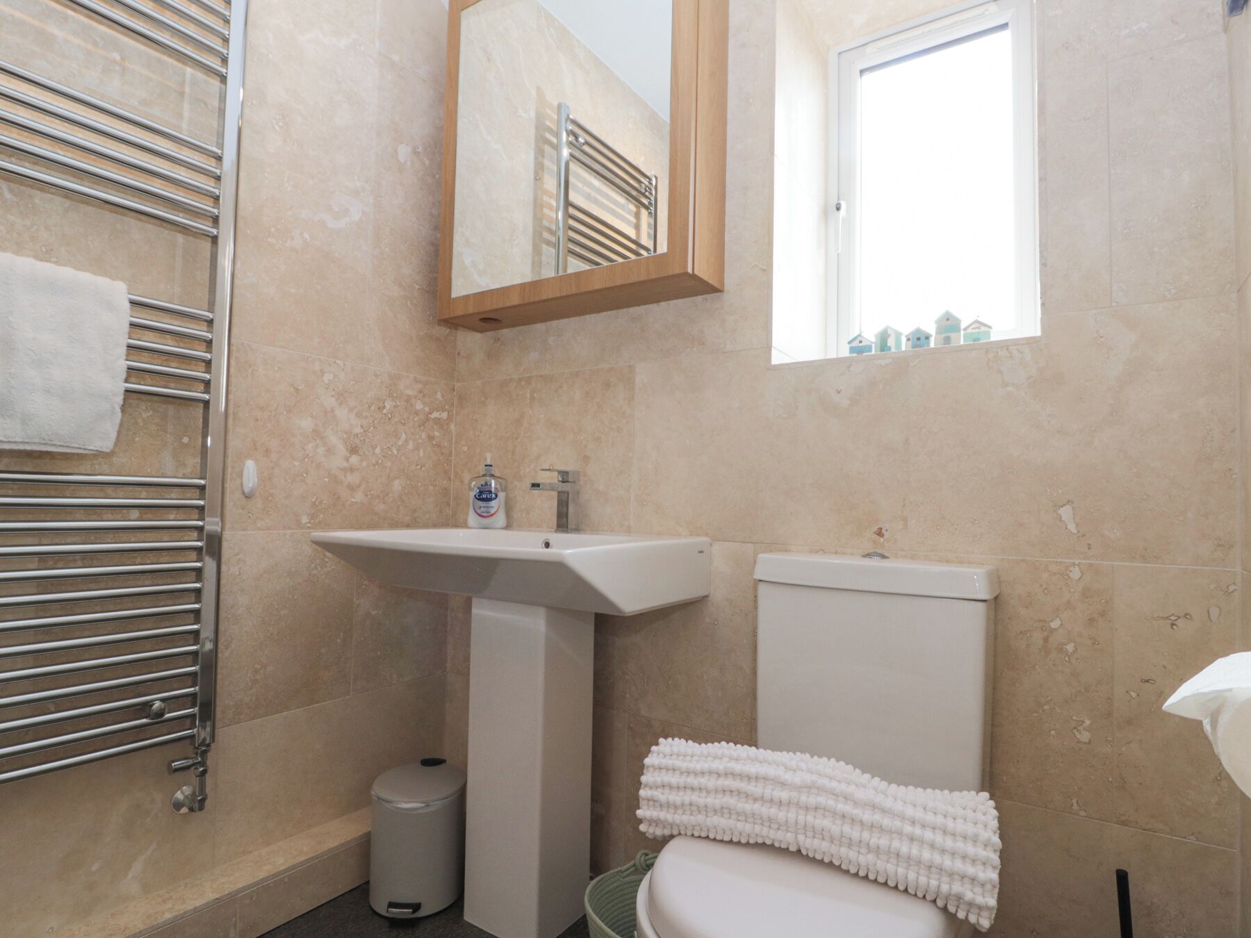 A bathroom with a sink, toilet, and towel rack.