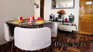 Zona pranzo con un tavolo rotondo, sedie e uno specchio sopra.