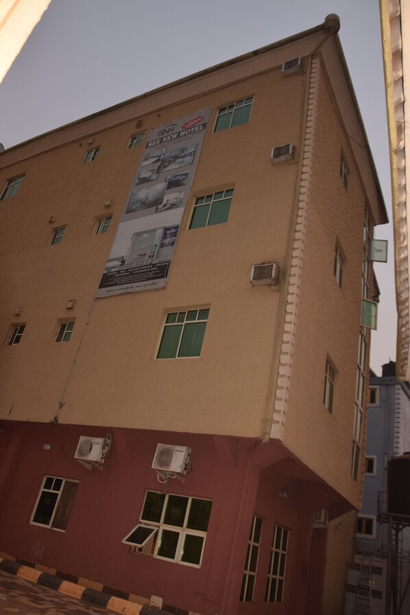 A multi-story building with a large advertisement on the side.