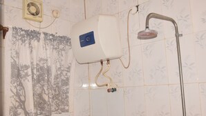 Ein Badezimmer mit Toilette, Dusche und einem Vorhang mit Baummuster.