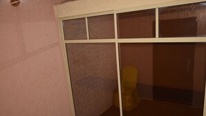Eine Raumecke mit strukturierter Wand und einer Glastür mit weißem Rahmen.