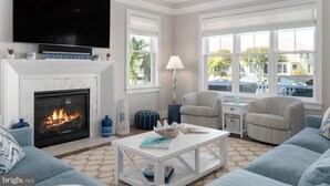 A living room with a fireplace, a flat-screen TV, and comfortable seating.