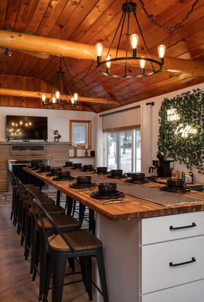 A spacious kitchen with a long island, bar stools, and a neon sign. - Sleeps 14! Hot Tub, GAME ROOM, ORV Trails & EASY lake access! (South Branch)