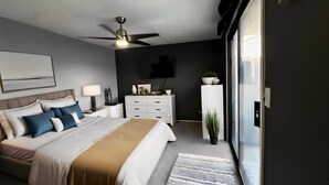 Una moderna camera da letto con un letto, comodini, una cassettiera, una ventola a soffitto e una TV appesa al muro.