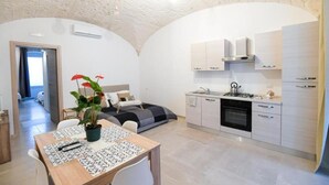 Un espace de vie compact comprenant une kitchenette, un coin repas et une chambre.