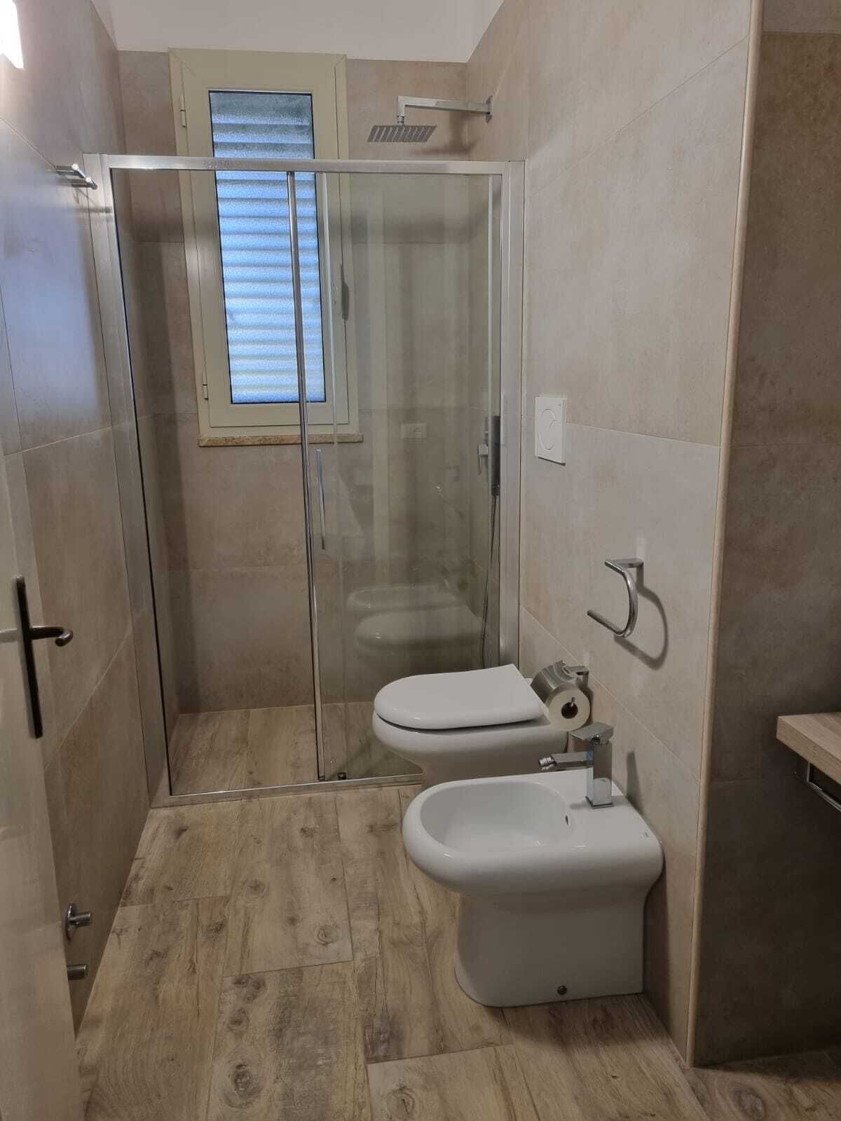 Une petite salle de bain avec une douche à parois de verre, des toilettes et un bidet.