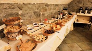 A buffet with various food items and beverages, arranged on a long table with baskets and containers.
