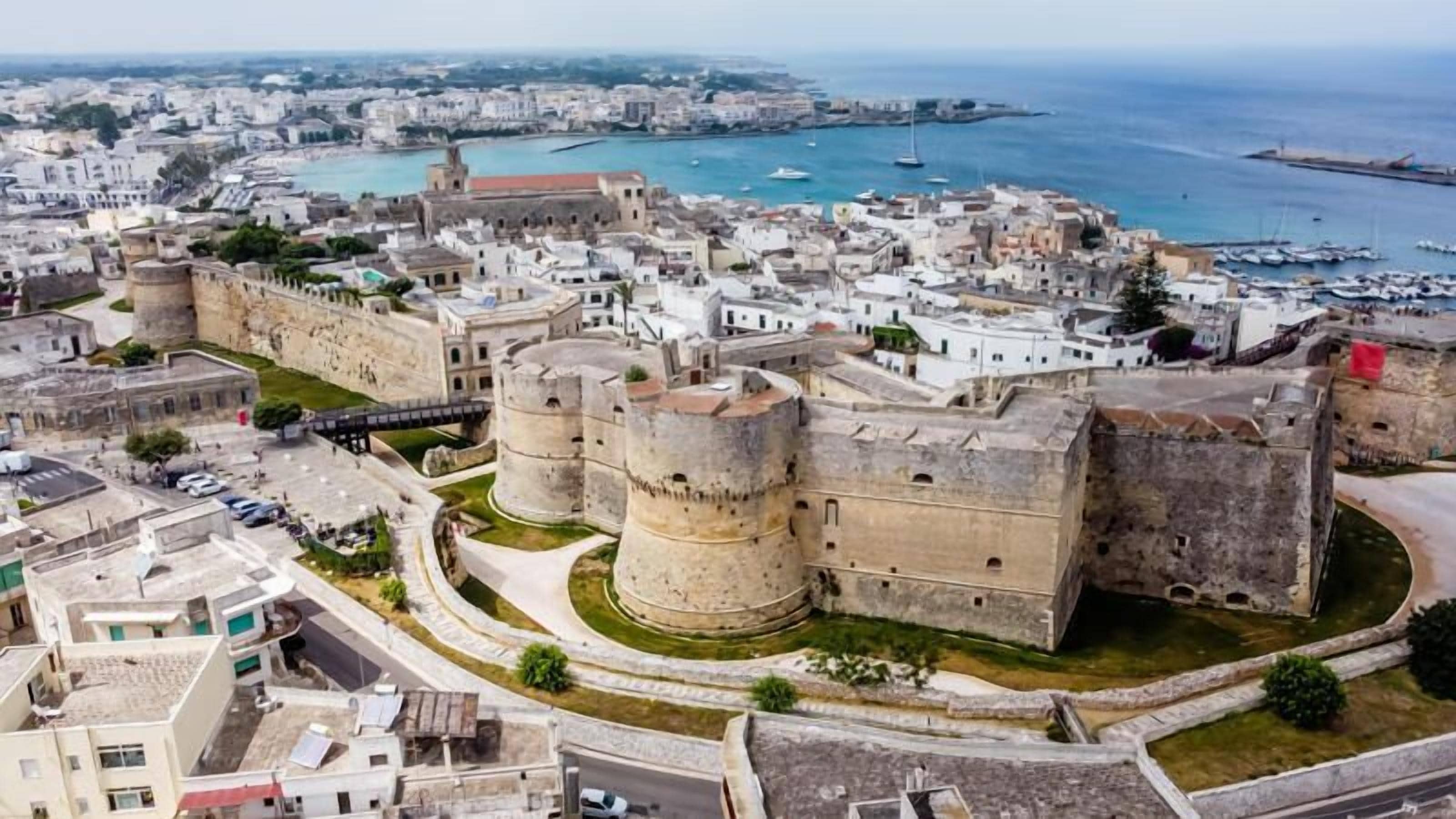 Uma cidade costeira com fortificações históricas e um porto de recreio.