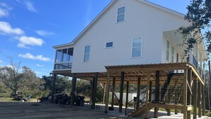 Una casa a due piani con un portico coperto e un balcone ben visibile.