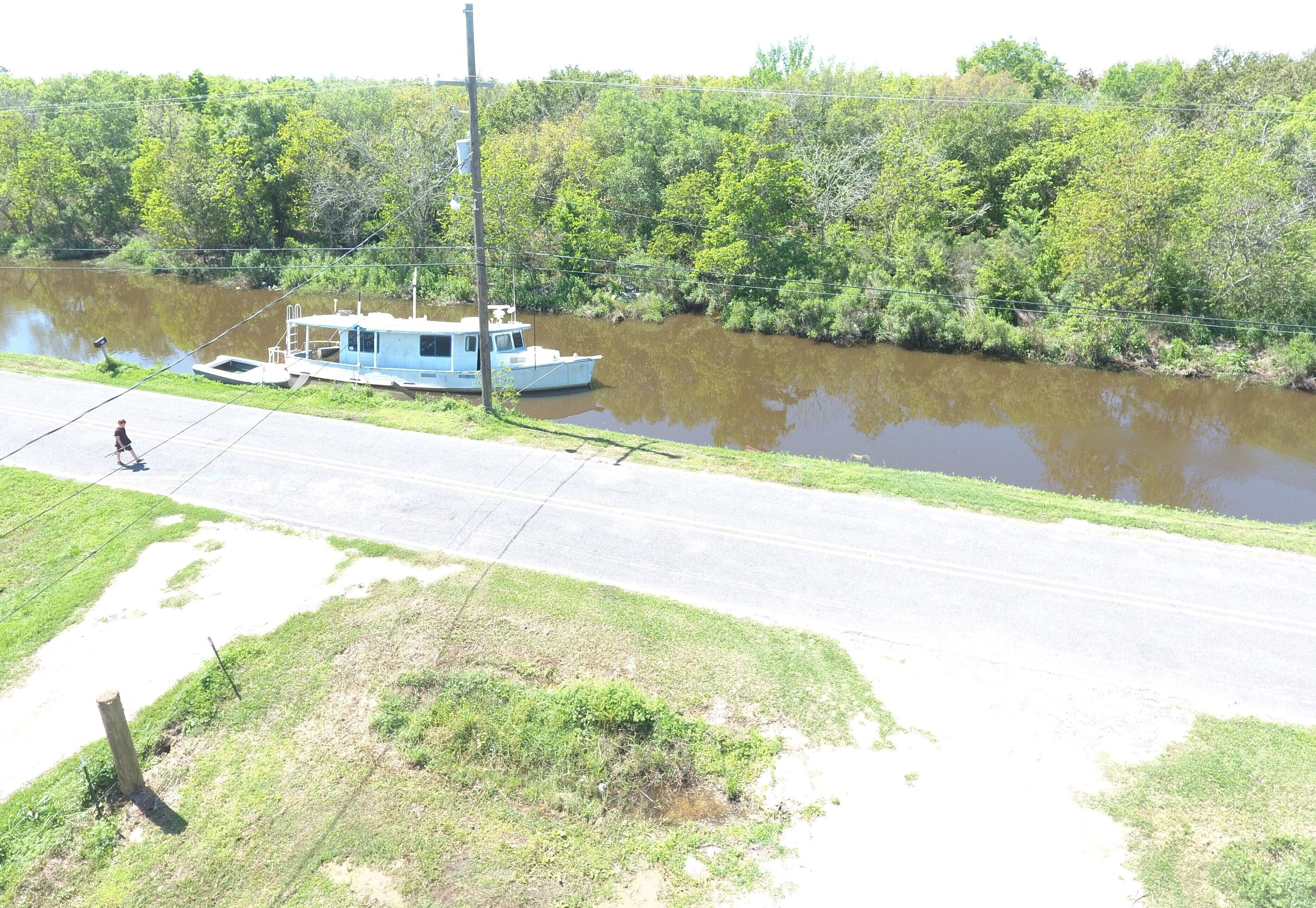 Une rivière avec un bateau amarré sur la rive droite.