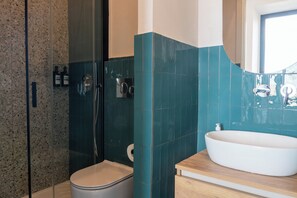 Habitació quàdruple Comfort | Bany | Dutxa, capçal de dutxa tipus cascada, tovalloles i sabó 