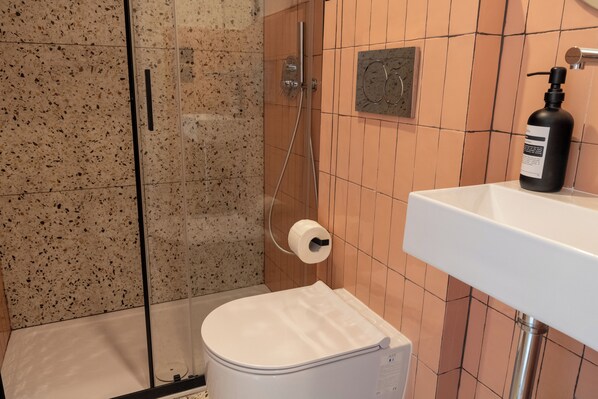 A bathroom with a shower, toilet, and sink. - Cunabu Apartments (Rome)