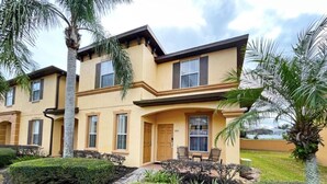 A two-story residential building with a beige facade, a front porch with a door, and a number "355" on the door. - Updated resort home, south facing patio and balcony! (Davenport)