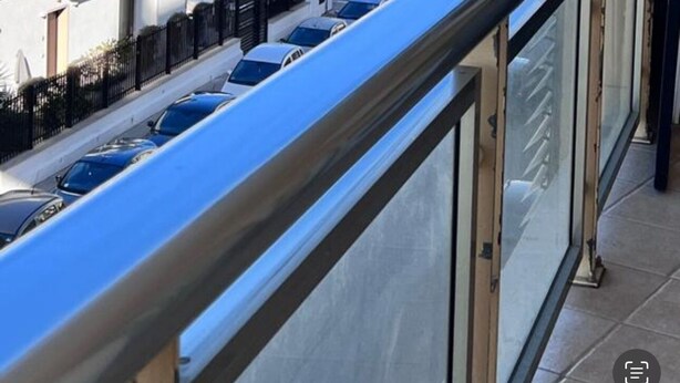 A view from a balcony overlooking a parking lot and a building with a sign for 'Euro Spin'.