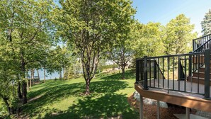 Une propriété résidentielle dotée d’une terrasse, d’une pelouse et d’arbres.