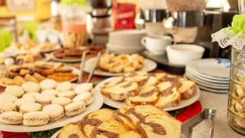 A buffet table with various food items including pastries and bread.