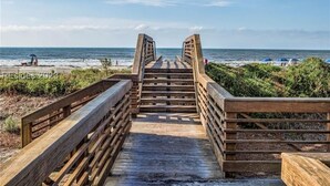 Una passerella in legno che conduce a una spiaggia con vista libera sull'oceano.