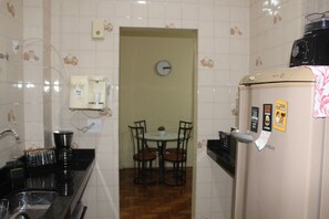 Enjoy meals at the dining table in this cozy kitchen area, complete with a refrigerator, sink, and coffee maker.
