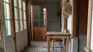 A hallway with a tiled floor, a wooden bench, and a door at the end. - Awesome View, Valparaiso Terrace (Valparaíso)