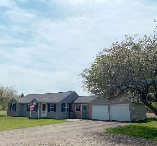 Ein Bungalow mit Garage und einer Veranda, sowie einer amerikanischen Flagge.
