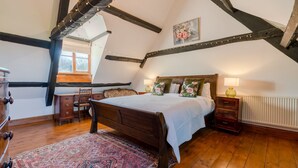 Een slaapkamer met een houten bed, een bureau en een radiator.