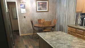 A kitchen with a wooden island, a dining table with chairs, and a refrigerator. - Centrally located between Bryson City, Sylva and Cherokee.5 mins to the Casino. (Whittier)