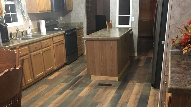 A kitchen with wooden cabinets, a central island, and a herringbone-patterned floor. - Centrally located between Bryson City, Sylva and Cherokee.5 mins to the Casino. (Whittier)