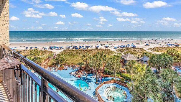 Un resort con piscina, playa y vista al océano.