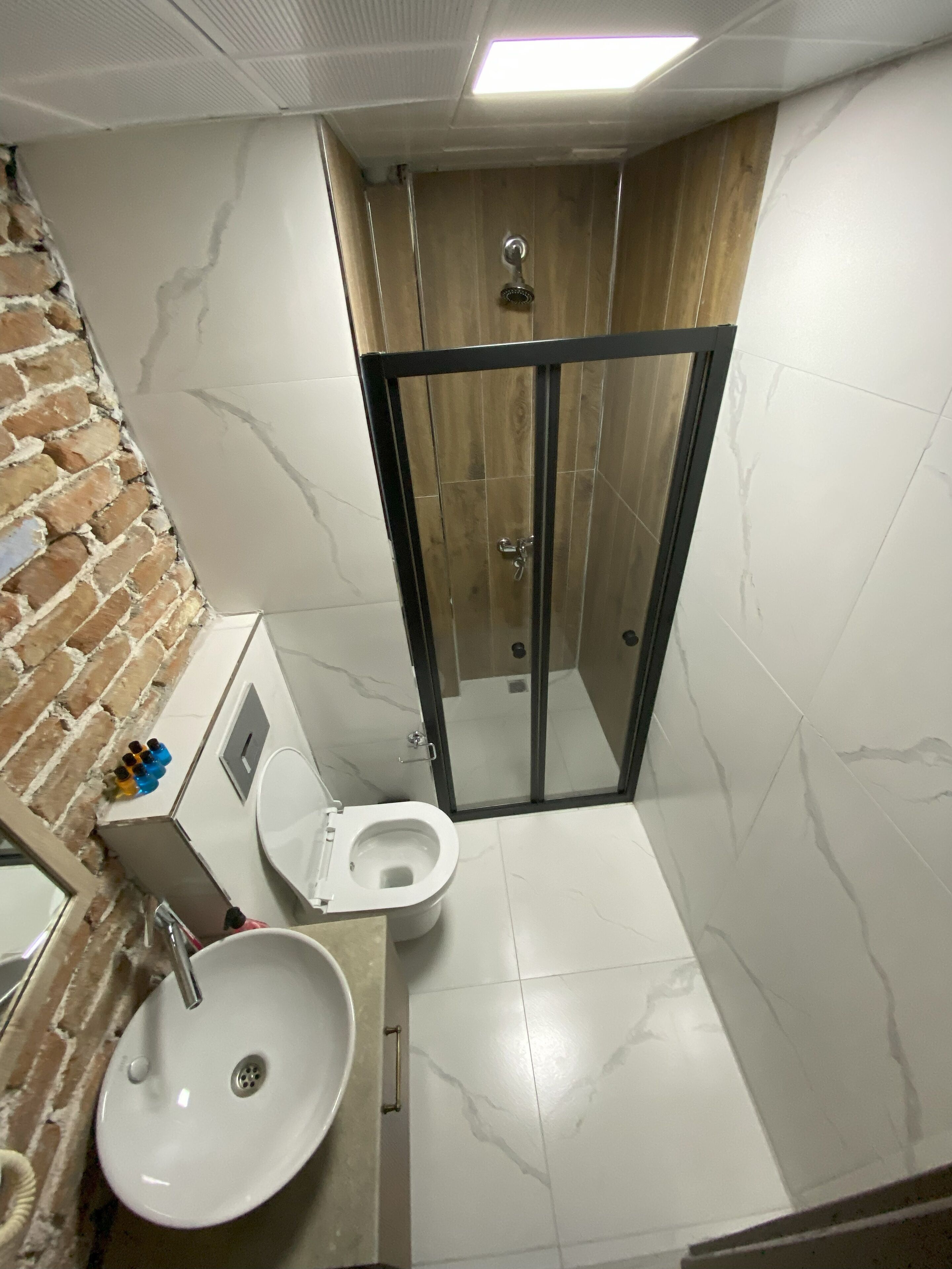 A bathroom with a toilet, sink, and shower.