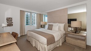 A modern hotel room with a large bed, bedside lamps, a desk, and a view of the cityscape through the window. - 1 Hotel Modern King Suite 1BR 1 5BA w Ocean View (Miami Beach)